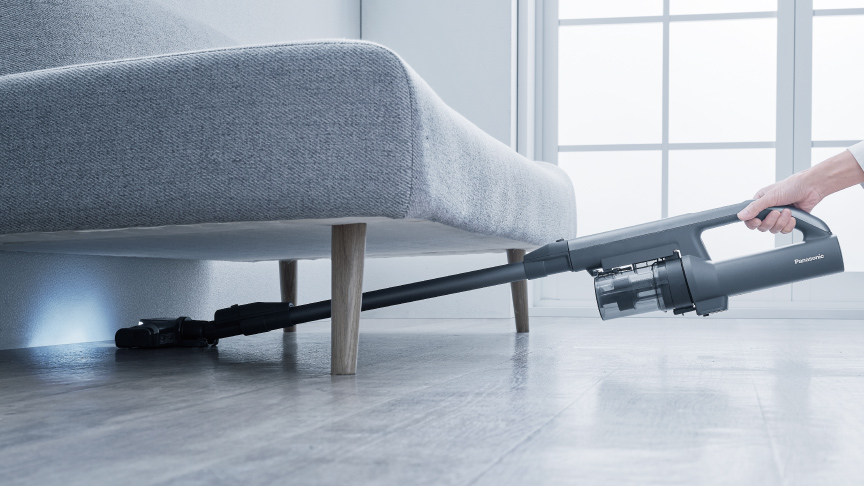 コードレス掃除機で暗い場所を掃除しているイメージ