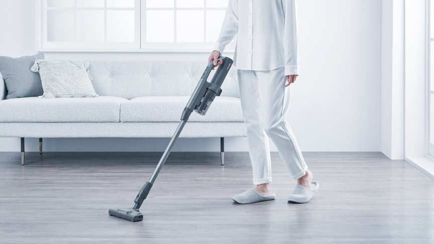 コードレス掃除機でリビングを掃除しているイメージ